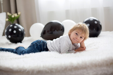 Poster - Cute child, lying in bed, reading book