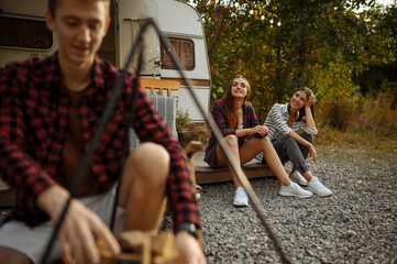 Wall Mural - happy friends prepares to cooking on campfire