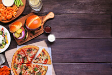 Healthy Plant Based Fast Food Side Border. Above View Over A Dark Wood Background. Table Scene With Cauliflower Crust Pizza, Bean Burgers And Vegetarian Sides. Copy Space.