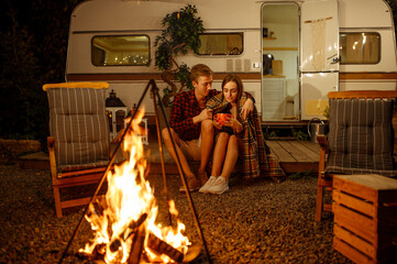Wall Mural - young love couple hugging by the campfire, picnic