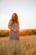© phpetrunina14 - beautiful mature woman in sundress at wheat field on sunset
