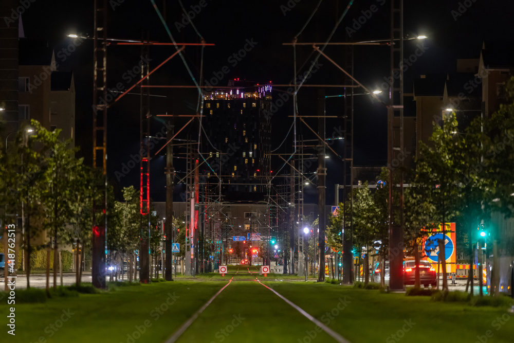 Tram rails on lawn in city center at night - obrazy, fototapety, plakaty 