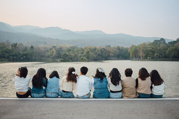 Picture from behind view of groups of friends embrace each other together. Concept for kindness support of people having fun with diversity millenials of gen z.