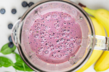 Wall Mural - Blueberry, banana and spinach smoothie with fresh berries and fruits in blender. Healthy drink. top view