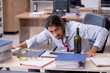 © Elnur - Young male employee drinking alcohol in the office