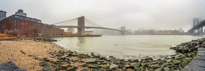 Fototapete - Brooklyn bridge and east river at foggy rainy day, New York City