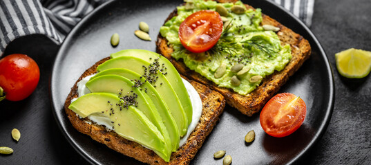 Breakfast sandchwich of homemade bread with Avocado, cream cheese, cherry tomato. Vegetarian food concept. Clean eating. Top view