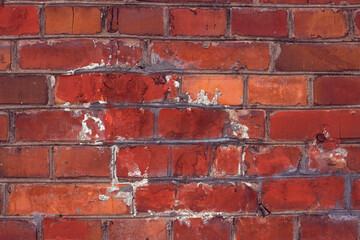 red brick textured and scratched wall with repaired area - close up, red textured background