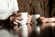 © Konstantin - Man and woman drinking coffee. framing on hands. Close up woman and man holding cups of coffee on table
