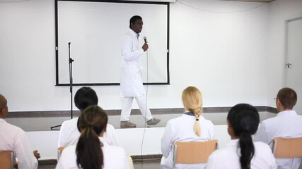 Wall Mural - Confident african american doctor attending lectures within refresher course. Professional development concept. High quality FullHD footage