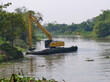 A backhoe is dredging a canal