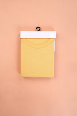 Poster - Yellow folded tshirts with packaging on wooden background