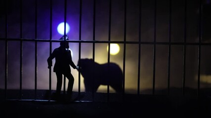 Wall Mural - Silhouette of a Bear miniature standing in a zoo cage with scared man ready to attack. Creative decoration with colorful backlight with fog. Selective focus