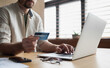 © kite_rin - Male hand holding credit card and using laptop at home, Businessman or entrepreneur working at office, e-commerce, online shopping, internet banking, spending money, working from home concept
