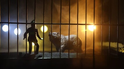 Wall Mural - Silhouette of a Bear miniature standing in a zoo cage with scared man ready to attack. Creative decoration with colorful backlight with fog. Selective focus