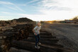 © Mint Images - 7 year old boy standing alone on railroad ties at sunset