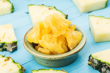 Wall Mural - Dried pineapple in the bowl on wood background