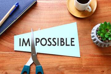Poster - man hand holding card with the text impossible, cutting the word im so it written possible. success and challenge concept.