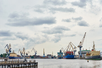 working crane bridge in shipyard and cargo ships in a port