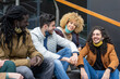 group of millennial friends chatting together and having fun, universitary students from different ethnicity smiling, joking and laughing