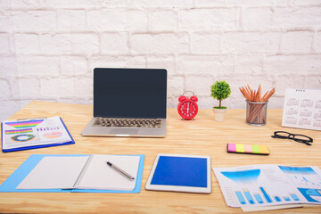 Office laptop business financial document chart and graph on wooden table with coffee cup. Flat lay notebook computer laptop on office desk. No people business graph chart mockup on business workspace