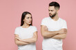 © ViDi Studio - Young irritated dissatisfied couple two friends man woman in white basic t-shirt quarrel swearing have problem stress need family psychologist isolated on pastel pink color background studio portrait