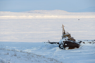 Wall Mural - winter arctic landscape. view of an old abandoned rusty ship near the coast of the frozen estuary. i
