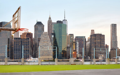 Wall Mural - Manhattan skyline seen from sport court at sunset, focus on background, USA.