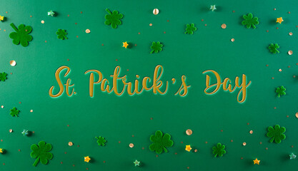 Wall Mural - Happy St. Patricks Day decoration concept. Flat lay, top view of clover leaves on green background with the text.