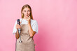 © Asier - Young russian cook woman holding an electric mixer isolated looking sideways with doubtful and skeptical expression.