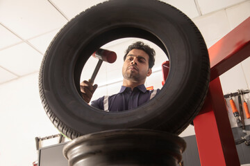 Wall Mural - Technician working on the quality  of a tyre at a tyre shop	