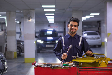 Wall Mural - Portrait of happy mechanic in auto repair shop	