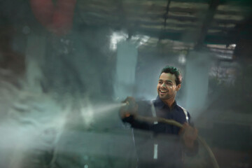 Wall Mural - Technician  cleaning the car with a high pressure washer at a car wash	