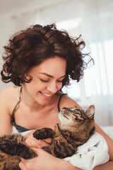 Wall Mural - Portrait view of the happy young woman spending time with her cat