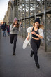 Junge Frauen laufen gutgelaunt über Brücke