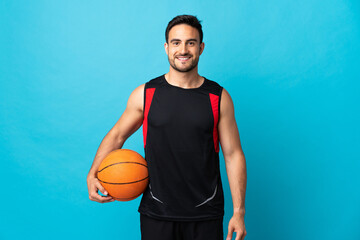 Young handsome man isolated on blue background playing basketball