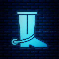 Poster - Glowing neon Cowboy boot icon isolated on brick wall background. Vector.