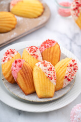 Delicious homemade chocolate dipped madeleine on white table background