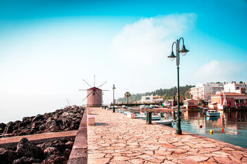 Wall Mural - charming seafront view with stones, lanterns and old windmill on the coast of the mon repose area in