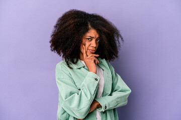 Wall Mural - Young african american curly woman isolated on purple background contemplating, planning a strategy, thinking about the way of a business.