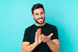 © luismolinero - Caucasian handsome man isolated on blue background applauding after presentation in a conference