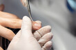 Woman nail manicure in a beauty salon. Closeup of manicurist making nail care. Manicure specialist cutting cuticule.
