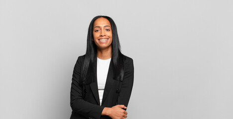 Wall Mural - young black woman laughing shyly and cheerfully, with a friendly and positive but insecure attitude. business concept