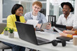 © Sofiia Shunkina - Office work concept. Team of positive purposeful creative multiracial colleagues discussing details of joint project, using infographics and modern gadgets, while working together in boardroom