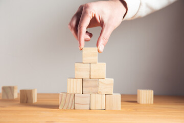 Canvas Print - business man holding wooden cubes