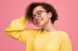 Happy young woman with curly hair and eyeglasses