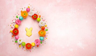 Wall Mural - Easter eggs, cookie and colorful spring flowers made in shape of egg on pastel pink background.