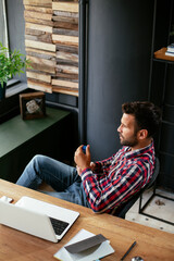 Wall Mural - Young businessman working in his office. Thirsty businessman drinking water..