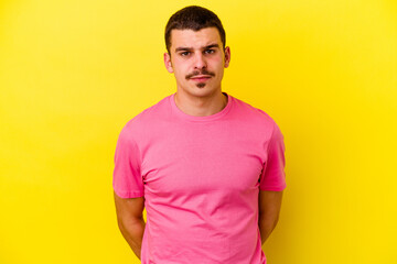 Young caucasian cool man isolated on yellow background sad, serious face, feeling miserable and displeased.