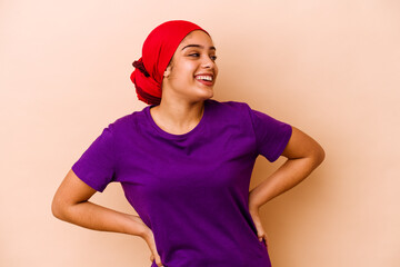 Wall Mural - Young african american woman isolated on beige background relaxed and happy laughing, neck stretched showing teeth.